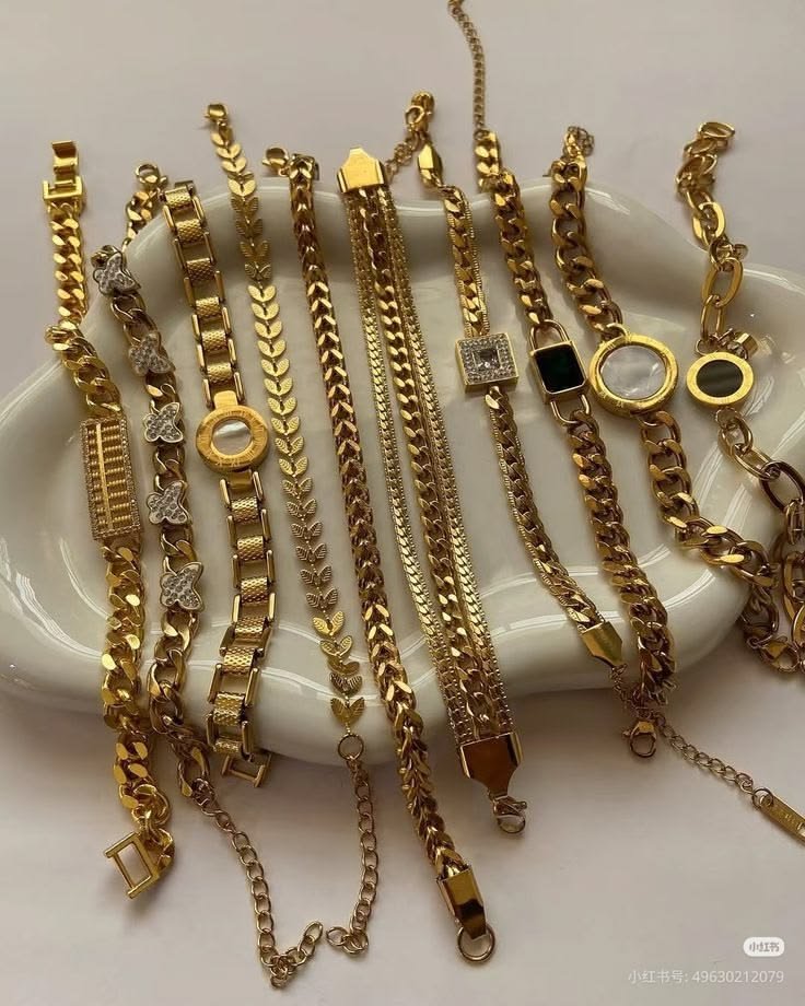 Gold chain and link bracelets laid out on a cloud-shaped dish